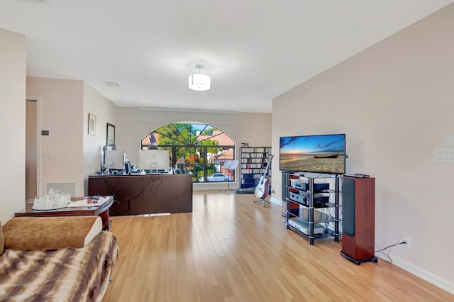 living room featuring light wood-type flooring, baseboards, and visible vents