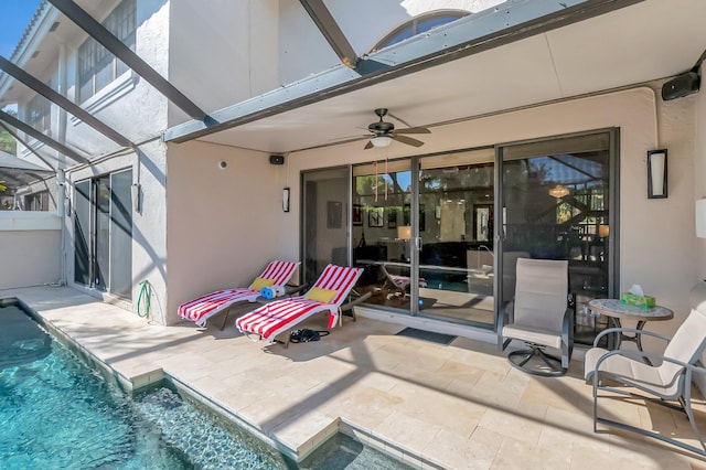 view of patio with a lanai, an outdoor pool, and ceiling fan