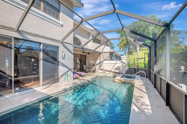 view of swimming pool with glass enclosure, a patio, and a pool with connected hot tub