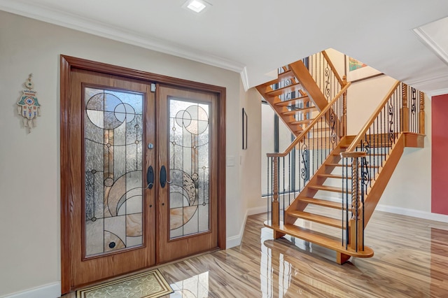 entrance foyer featuring ornamental molding, french doors, stairway, light wood finished floors, and baseboards