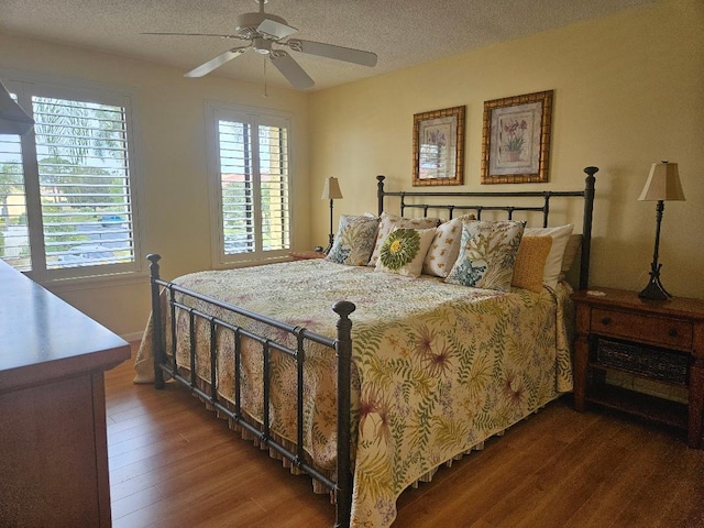 bedroom with a textured ceiling, ceiling fan, and wood finished floors