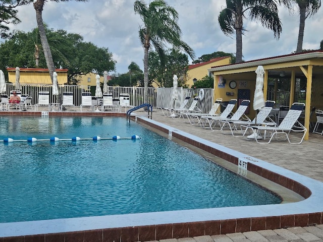 pool with a patio and fence