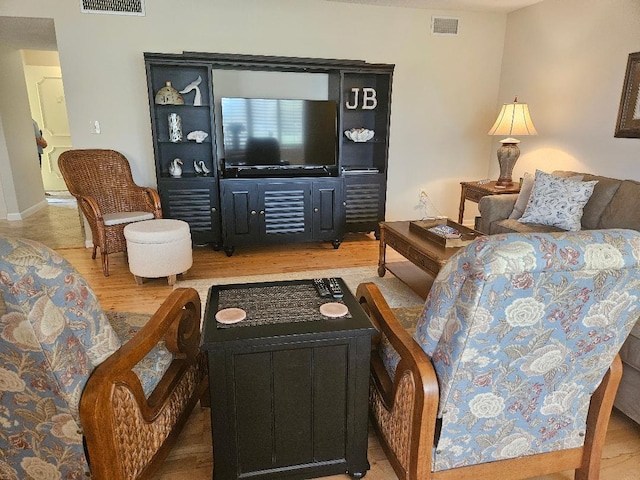 living area with visible vents and wood finished floors