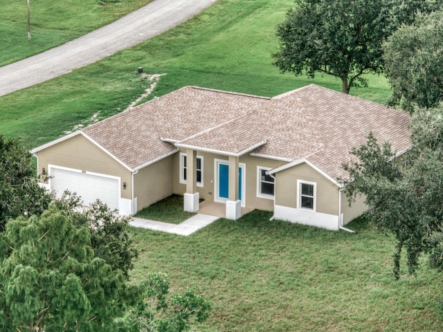 view of front of house with stucco siding, a garage, a front yard, and a shingled roof