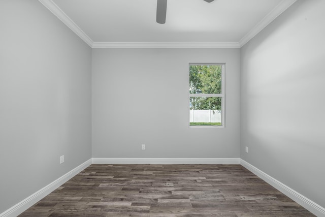 spare room with dark wood finished floors, crown molding, and baseboards