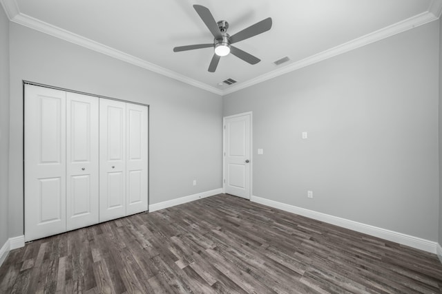 unfurnished bedroom featuring baseboards, dark wood-style floors, visible vents, and ornamental molding