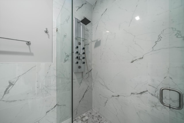 bathroom featuring a marble finish shower