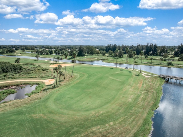 drone / aerial view featuring golf course view and a water view