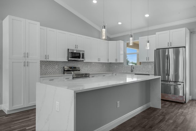 kitchen with ornamental molding, a center island, white cabinetry, stainless steel appliances, and lofted ceiling