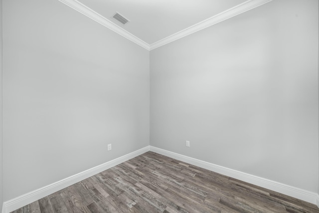 unfurnished room with dark wood finished floors, visible vents, baseboards, and ornamental molding