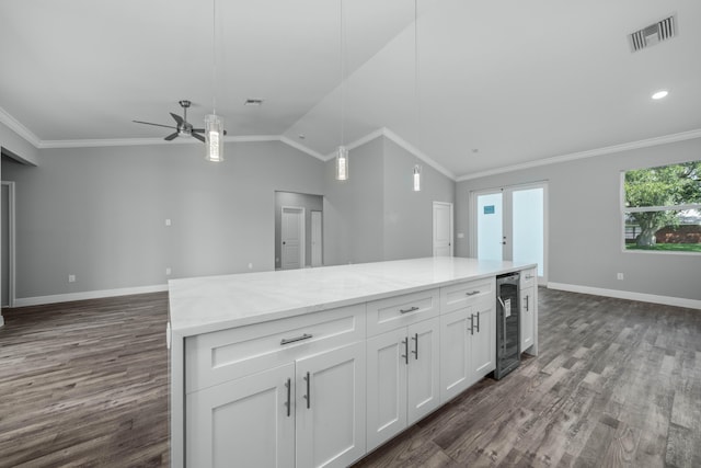 kitchen featuring visible vents, ornamental molding, wine cooler, white cabinets, and open floor plan