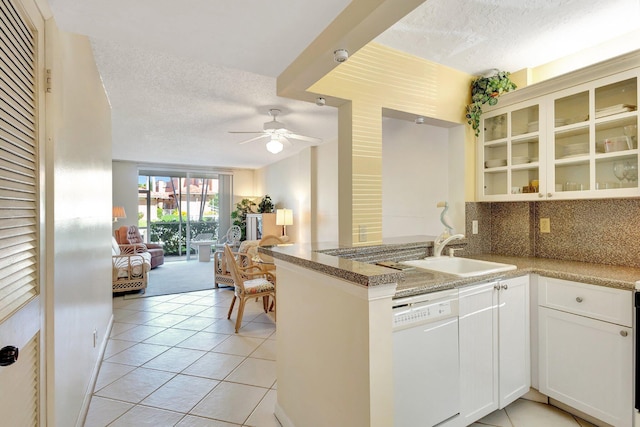 kitchen with backsplash, open floor plan, dishwasher, a peninsula, and a sink