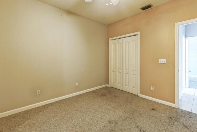 unfurnished bedroom featuring a closet, baseboards, visible vents, and carpet floors