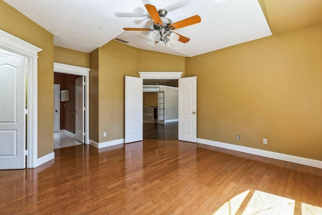 unfurnished bedroom featuring visible vents, ceiling fan, baseboards, and wood finished floors