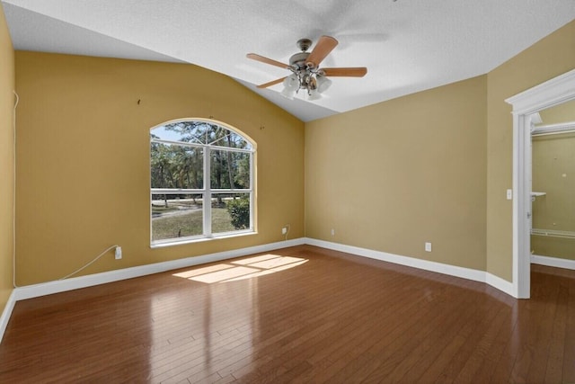 spare room with baseboards, wood-type flooring, ceiling fan, and vaulted ceiling