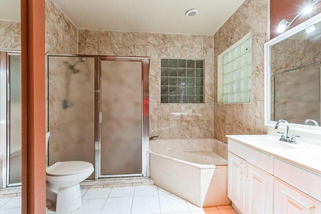 bathroom featuring a garden tub, tile walls, a shower stall, tile patterned flooring, and vanity