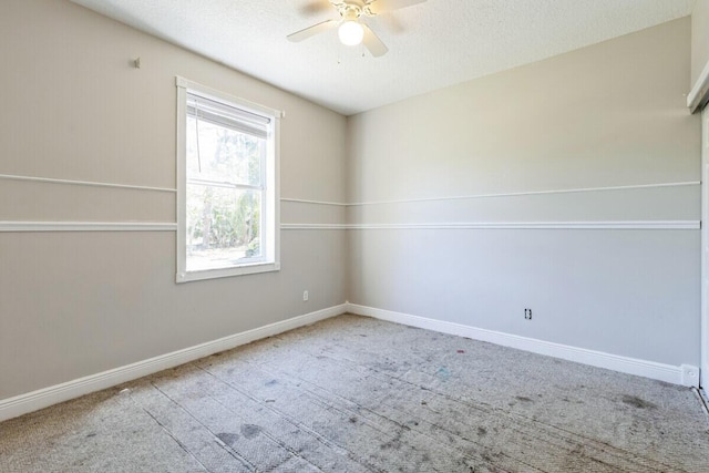 empty room with carpet, a ceiling fan, baseboards, and a textured ceiling