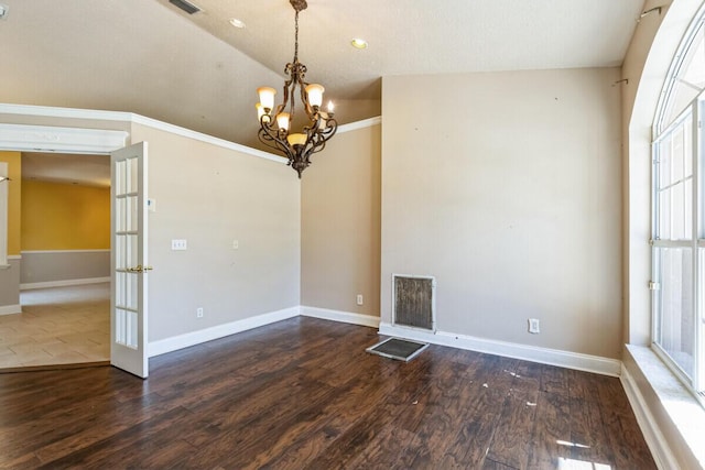 interior space with wood finished floors, visible vents, baseboards, lofted ceiling, and a notable chandelier