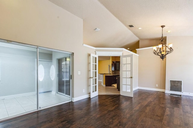 unfurnished living room featuring french doors, lofted ceiling, visible vents, and wood finished floors