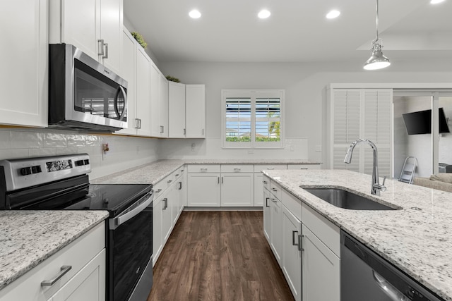 kitchen featuring a sink, decorative backsplash, white cabinets, and stainless steel appliances