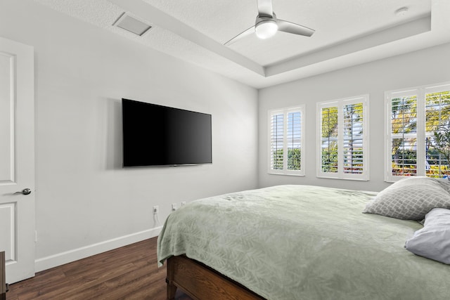 bedroom featuring visible vents, multiple windows, baseboards, and wood finished floors