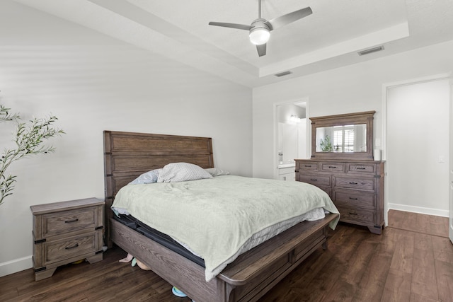 bedroom featuring visible vents, a raised ceiling, and dark wood-style flooring