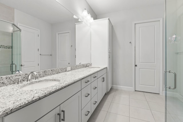 bathroom with double vanity, tile patterned floors, a stall shower, and a sink