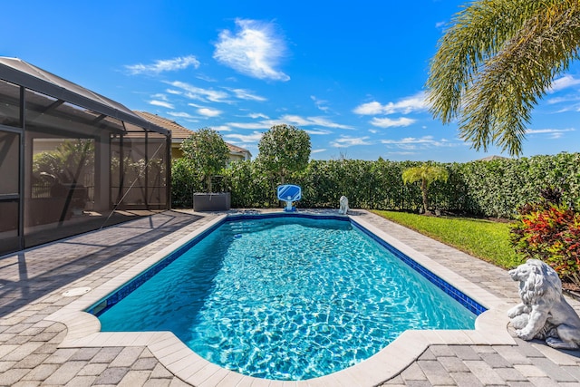 view of swimming pool with glass enclosure, a patio, and a fenced in pool