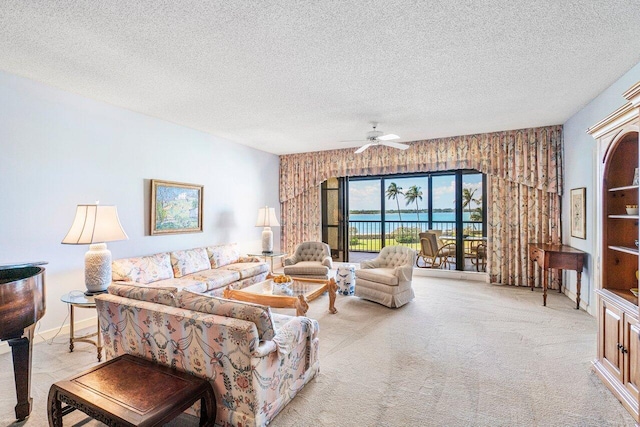 living area featuring a textured ceiling, carpet, and ceiling fan