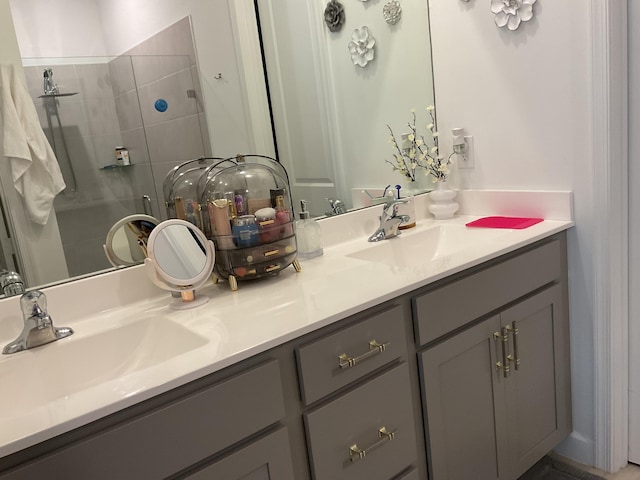 full bath with double vanity, a stall shower, and a sink