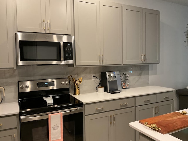 kitchen with stainless steel appliances, backsplash, and gray cabinets