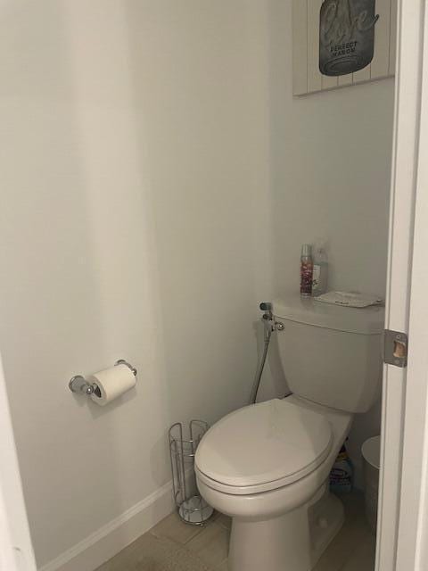 bathroom with baseboards and toilet