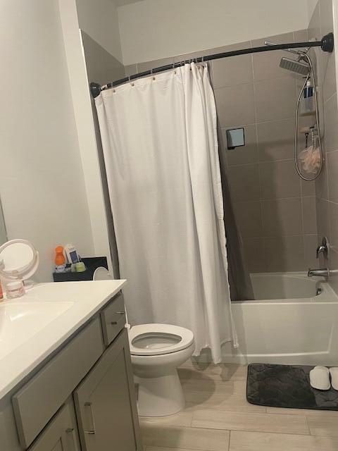 bathroom with toilet, shower / bath combo, and vanity