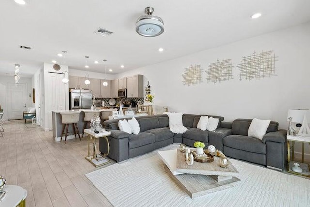 living area featuring recessed lighting, visible vents, and light wood finished floors