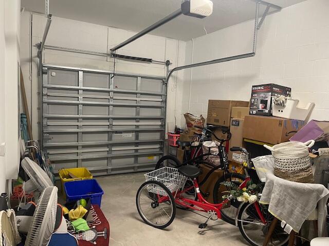 garage featuring concrete block wall and a garage door opener