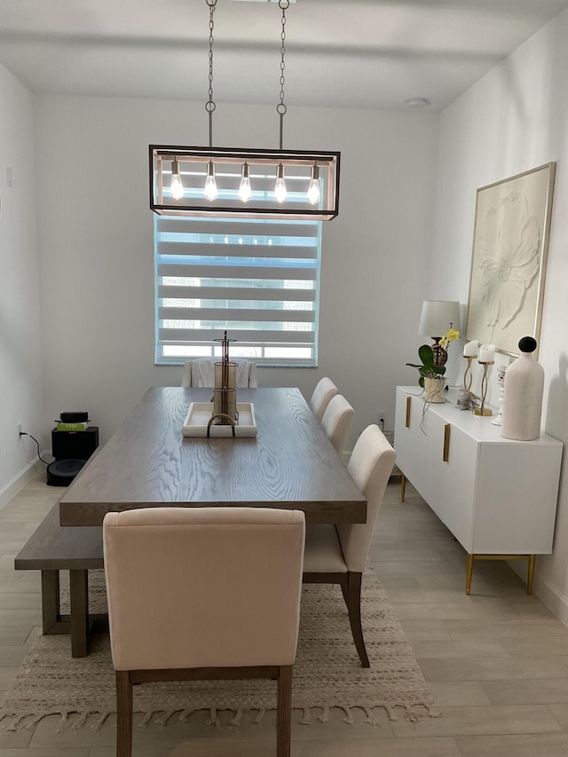 dining area featuring baseboards and light wood-type flooring