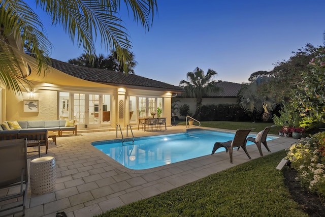 outdoor pool featuring a patio, a yard, french doors, and an outdoor hangout area