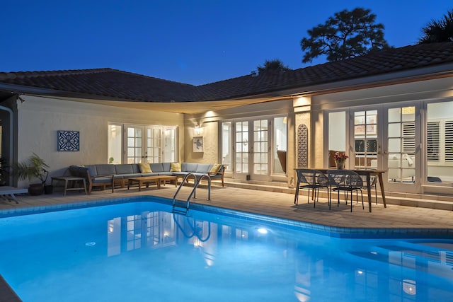 outdoor pool with french doors, a patio, and outdoor lounge area