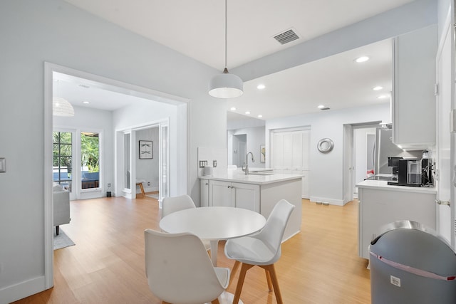 dining space featuring light wood-type flooring, visible vents, baseboards, and recessed lighting