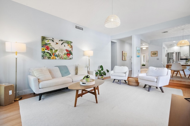 living room with light wood-style floors and visible vents