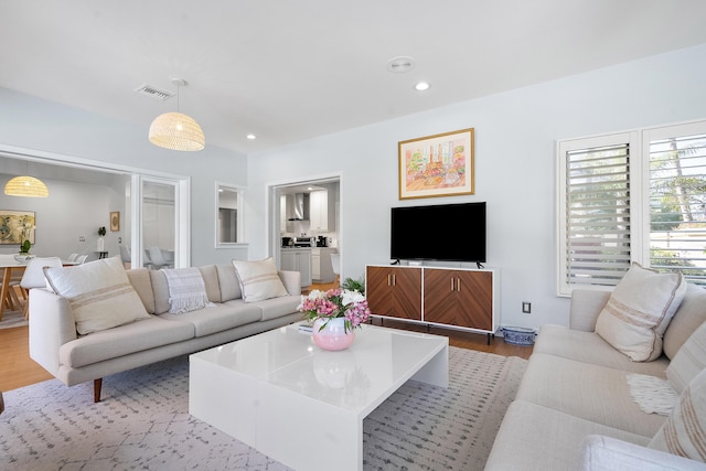 living area with recessed lighting, wood finished floors, and visible vents