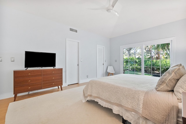 bedroom featuring ceiling fan, visible vents, wood finished floors, and vaulted ceiling