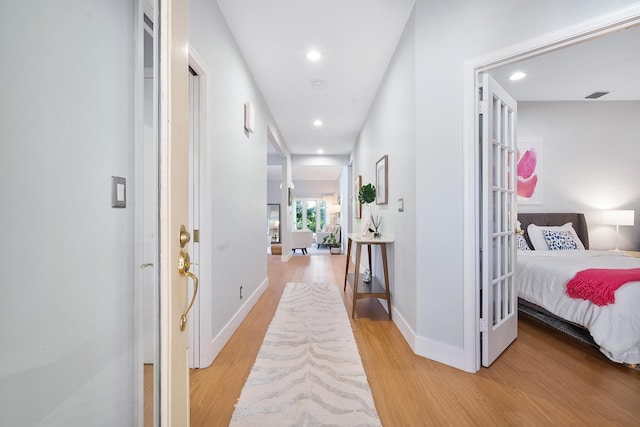 hall featuring light wood-style flooring, recessed lighting, baseboards, and visible vents