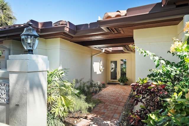 doorway to property with a patio, french doors, and stucco siding