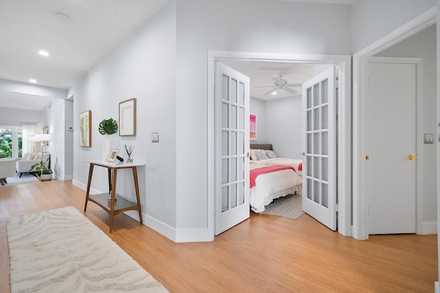 corridor featuring recessed lighting, french doors, baseboards, and light wood-style floors