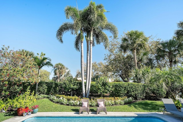 outdoor pool featuring a yard and fence