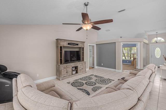 living room with visible vents, a ceiling fan, a textured ceiling, light tile patterned flooring, and lofted ceiling