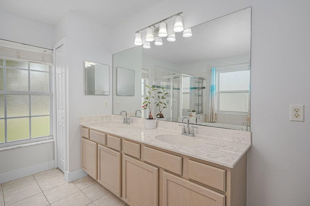 bathroom with tile patterned floors, a shower stall, double vanity, and a sink