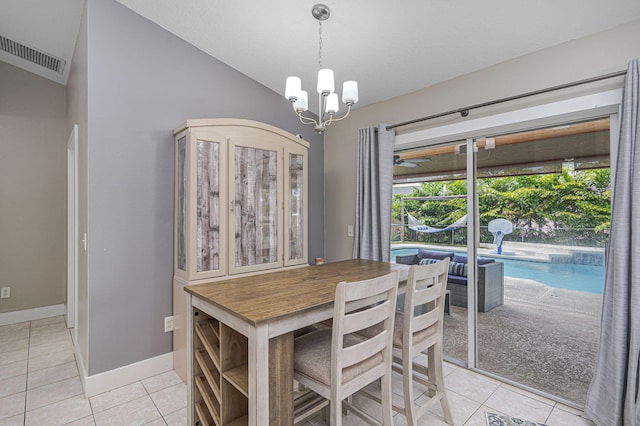 dining area with visible vents, baseboards, vaulted ceiling, light tile patterned floors, and a notable chandelier