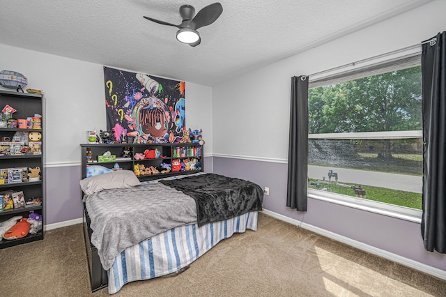 bedroom with baseboards, carpet floors, a textured ceiling, and a ceiling fan